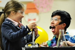 Young girl and woman scientist performing experiment